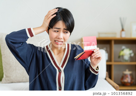 通帳を見て悩む若い女性 通帳を見て悩む若い女性 101356892