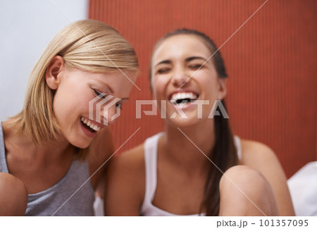 Shes the funniest girl I know. Two friends laughing while sitting in their pajamas. 101357095