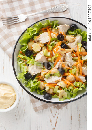 Chicken salad with mushrooms, carrots, celery, olives, cheese and lettuce close-up in a bowl. Vertical top view Chicken salad with mushrooms, carrots, celery, olives, cheese and lettuce close-up in a bowl. Vertical top view 101357501