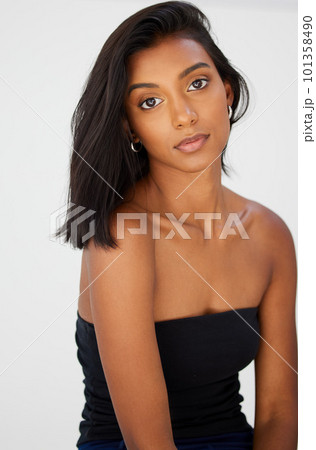 .Portrait, beauty and confidence with a model indian woman in her home, feeling beautiful or proud. Face, hair or relax with an attractive young female in her apartment looking confident or feminine. 101358490