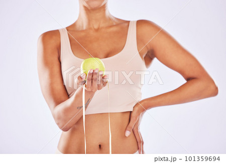 Apple, health and tape measure for diet of woman in studio for healthy lifestyle, weight loss or fitness. Female on a white background for wellness and fruit motivation in hand for healthcare goals 101359694