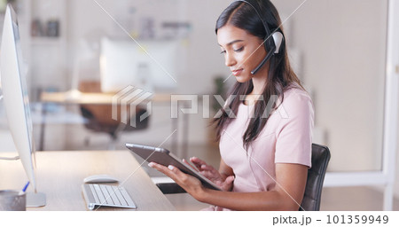 Young female customer service agent working in ecommerce and sales. Business woman working on a tablet in her office while helping and assisting customers online with IT support Young female customer service agent working in ecommerce and sales. Business woman working on a tablet in her office while helping and assisting customers online with IT support 101359949