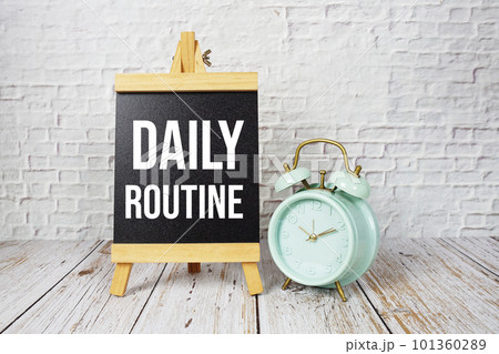 Daily Routine text message and alarm clock on wooden background Daily Routine text message and alarm clock on wooden background 101360289