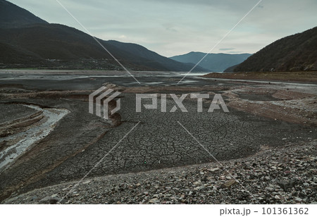 The river grows shallow, the bottom revealed in fresh cracks, the barren valley. 101361362