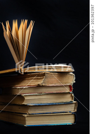 Stack of hardcover old books with an open book on a dark background. Bookshelf shop, Knowledge publications, literature. Bookish bookstore bookstore Stack of hardcover old books with an open book on a dark background. Bookshelf shop, Knowledge publications, literature. Bookish bookstore bookstore 101362397