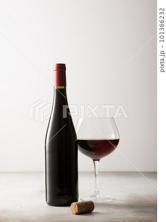 Bottle and glass of red wine with cork on light background. Bottle and glass of red wine with cork on light background. 101366232