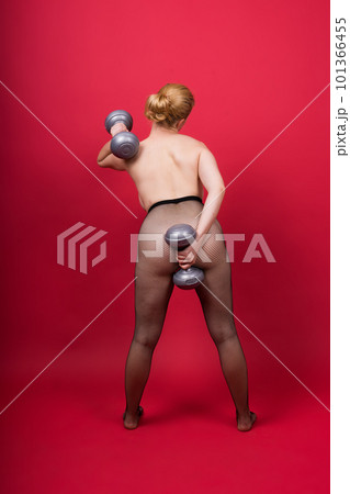 Seductive beautiful fitness female, athletic woman working out with dumbbells. Isolated in studio 101366455
