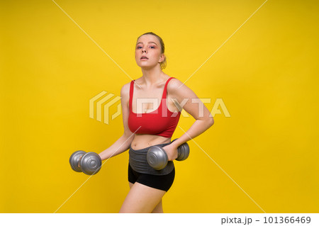Seductive beautiful fitness female, athletic woman working out with dumbbells. Isolated in studio 101366469