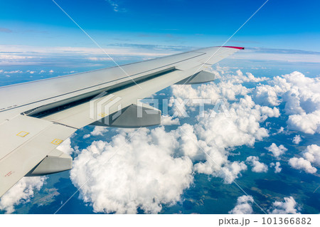 View from the airplane window at a beautiful cloudy sky and the airplane wing View from the airplane window at a beautiful cloudy sky and the airplane wing 101366882