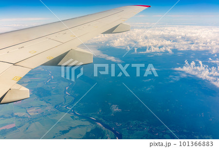 View from the airplane window at a beautiful cloudy sky and the airplane wing View from the airplane window at a beautiful cloudy sky and the airplane wing 101366883
