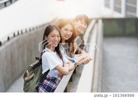 Young Asian woman college student with friends at outdoors. College student working on the college campus, education, school, study 101366986