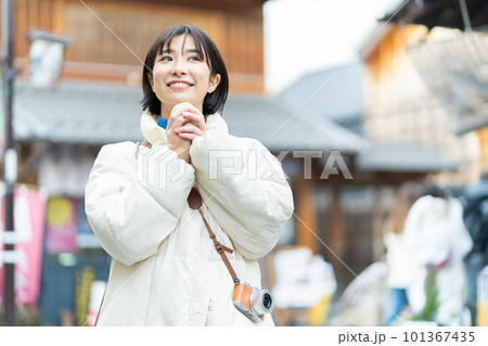 食べ歩きをする女性　観光する女性　観光、女性、旅行、笑顔、一人旅、記念写真 101367435