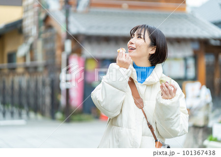 食べ歩きをする女性　観光する女性　観光、女性、旅行、笑顔、一人旅、記念写真 101367438