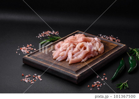 Raw chicken fillet cut into strips with spices and herbs Raw chicken fillet cut into strips with spices and herbs 101367500
