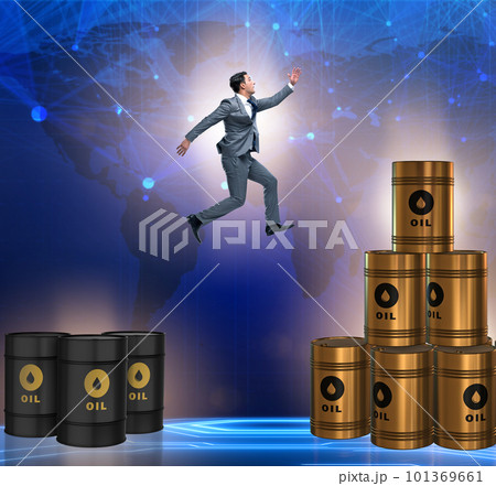Businessman jumping from stack of oil barrels 101369661