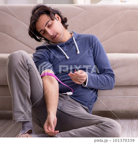 Young man having problems with narcotics at home 101370339