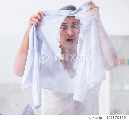 Inattentive husband burning clothing while ironing 101370366