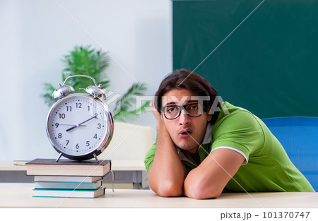 Young male student in front of green board 101370747