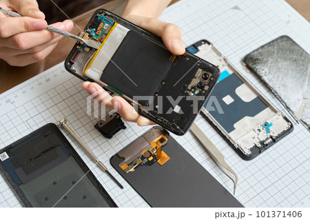 スマートフォンの分解をする手元 スマートフォンの分解をする手元 101371406