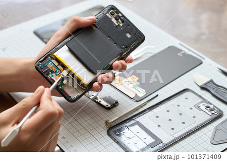 スマートフォンの分解をする手元 スマートフォンの分解をする手元 101371409