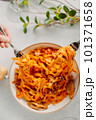 Italian pasta, tomato sauce. Two female hands in the frame, girls eat pasta, hold forks in their hands, top view, Italian cuisine. 101371658