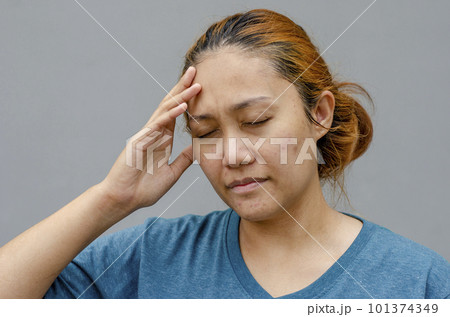 Asian women touch their temples right side, feel a headache or dizzy, feeling tired. grey background 101374349