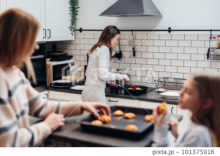 Young woman cooking pancakes in a frying pan 101375016