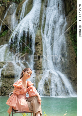Young Asian woman sitting on a chair In front of the Khoun Moung Keo Waterfall Young Asian woman sitting on a chair In front of the Khoun Moung Keo Waterfall 101375976