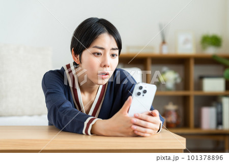 スマホ見て悩む若い女性 スマホ見て悩む若い女性 101378896