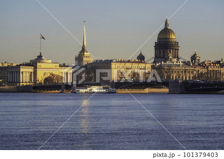 Tourist ship is sailing under the bridge. Spring St. Petersburg with a view of St. Isaac's Cathedral. View from the Neva River. Sunset view of the Palace Bridge, city life, postcard views. Tourist ship is sailing under the bridge. Spring St. Petersburg with a view of St. Isaac's Cathedral. View from the Neva River. Sunset view of the Palace Bridge, city life, postcard views. 101379403