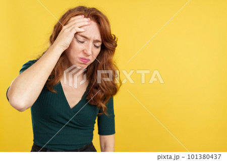 Beauty redheaded woman gesturing headache with the hand on head Beauty redheaded woman gesturing headache with the hand on head 101380437