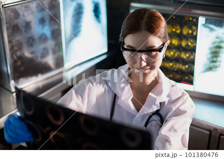 Doctor woman looking check up x-ray film in medical laboratory at hospital. 101380476