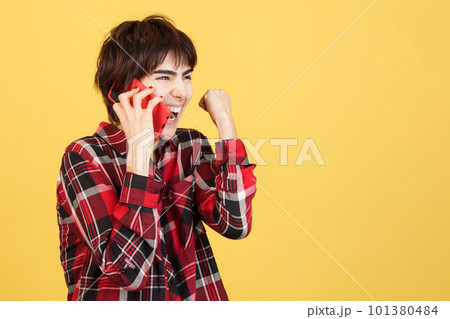Androgynous person celebrating while talking to the mobile 101380484