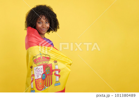 Migrant woman with afro hair wrapped with a Spanish flag 101380489