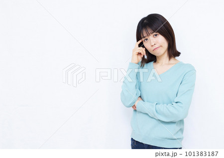白い背景の前で頭を抱えて悩む30代の女性 101383187