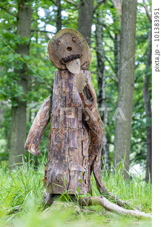 Funny figure made of wood stands in the woods. 101383951