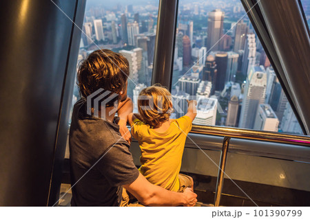 Dad and son are looking at Kuala lumpur cityscape. Panoramic view of Kuala Lumpur city skyline evening at sunset skyscrapers building in Malaysia. Traveling with kids concept Dad and son are looking at Kuala lumpur cityscape. Panoramic view of Kuala Lumpur city skyline evening at sunset skyscrapers building in Malaysia. Traveling with kids concept 101390799