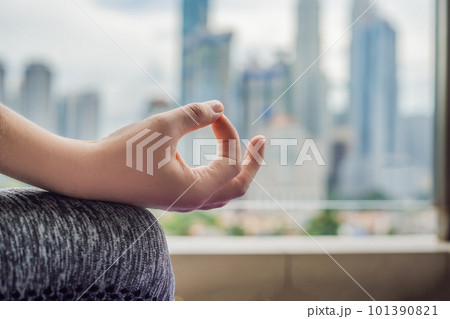 Young woman is practicing yoga in the morning on her balcony with a panoramic view of the city and skyscrapers 101390821