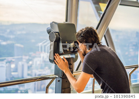 Man looks at Kuala lumpur cityscape. Panoramic view of Kuala Lumpur city skyline evening at sunset skyscrapers building in Malaysia Man looks at Kuala lumpur cityscape. Panoramic view of Kuala Lumpur city skyline evening at sunset skyscrapers building in Malaysia 101390845