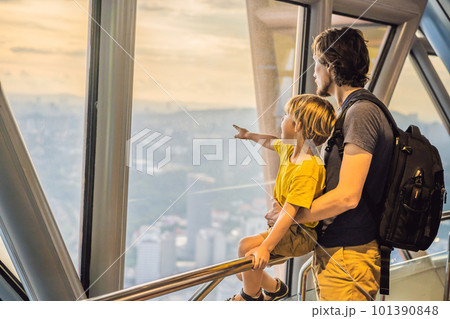 Dad and son are looking at Kuala lumpur cityscape. Panoramic view of Kuala Lumpur city skyline evening at sunset skyscrapers building in Malaysia. Traveling with kids concept Dad and son are looking at Kuala lumpur cityscape. Panoramic view of Kuala Lumpur city skyline evening at sunset skyscrapers building in Malaysia. Traveling with kids concept 101390848