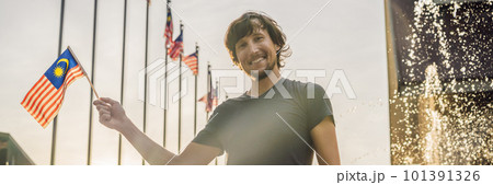 Young man travels in Malaysia. Holds the Malaysian flag BANNER, LONG FORMAT 101391326