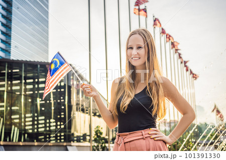 Young woman travels in Malaysia. Holds the Malaysian flag 101391330