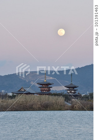 山焼きの終わった黒い若草山と夕暮れの薬師寺と月の風景 101391463