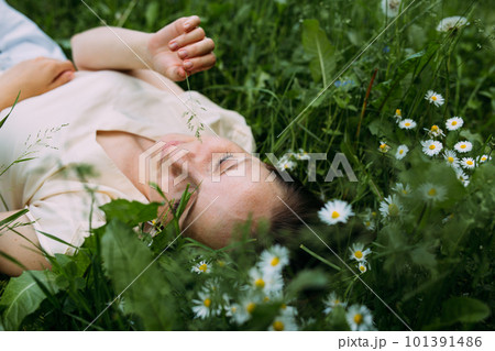 Beautiful woman with natural beauty without makeup lies in the grass in summer 101391486