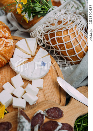 Picnic in the field with berries, juice, cheese, sausage and sweet croissants 101391487