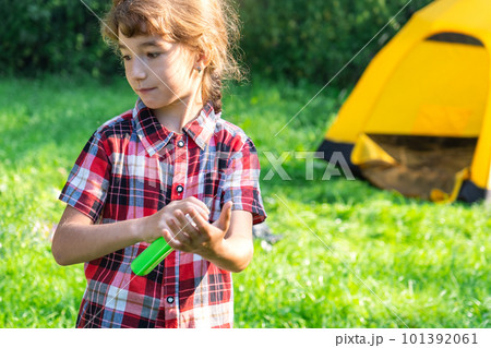Girl sprays mosquito spray on the skin in nature that bite her hands and feet. Protection from insect bites, repellent safe for children. Outdoor recreation, against allergies. Summer time Girl sprays mosquito spray on the skin in nature that bite her hands and feet. Protection from insect bites, repellent safe for children. Outdoor recreation, against allergies. Summer time 101392061