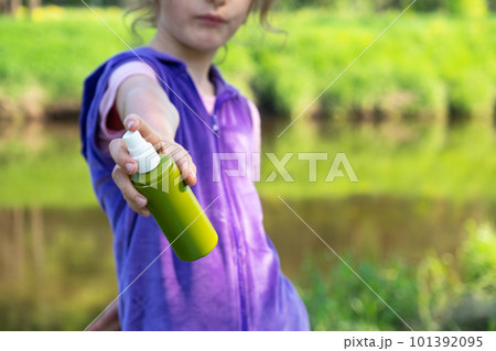 Girl sprays mosquito spray on the skin in nature that bite her hands and feet. Protection from insect bites, repellent safe for children. Outdoor recreation, against allergies. Summer time Girl sprays mosquito spray on the skin in nature that bite her hands and feet. Protection from insect bites, repellent safe for children. Outdoor recreation, against allergies. Summer time 101392095