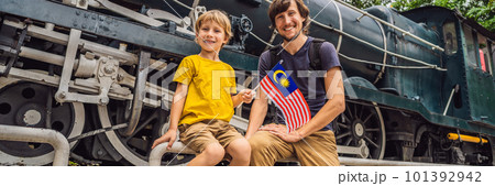 Father and son travelers in malaysia with malaysia flag celebrating the Malaysia independence day and Malaysia day. Travel to Malaysia concept BANNER, LONG FORMAT 101392942