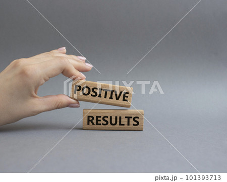 Positive results symbol. Concept words Positive results on wooden blocks. Beautiful grey background. Businessman hand. Business and Positive results concept. Copy space. 101393713