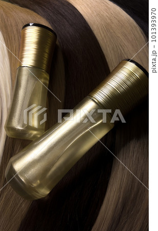 A strand of natural hair for extensions with a bottle of care product. 101393970